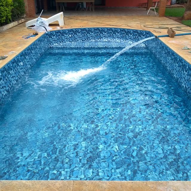 Piscina com vinil estampado sendo enchida após a instalação